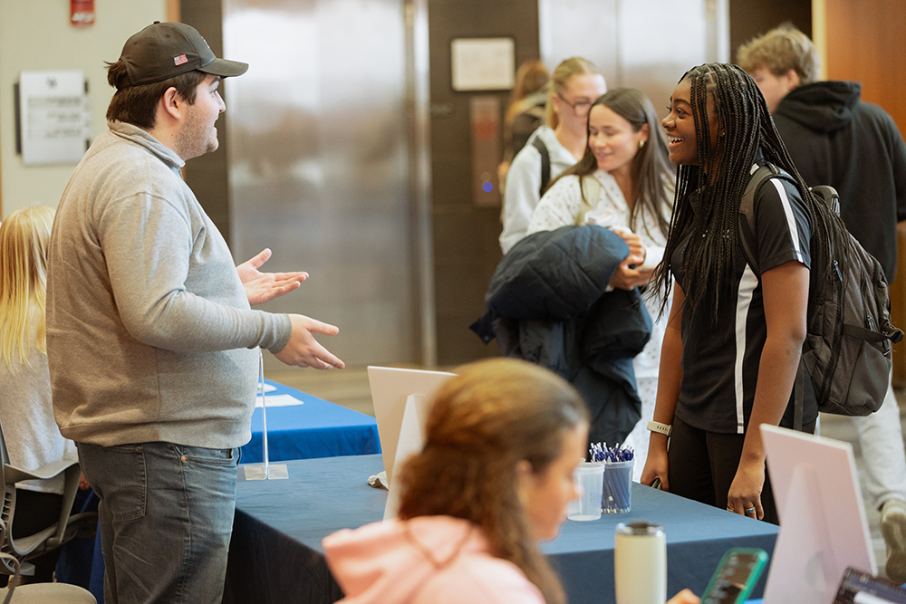 A Person speaking with a student about leadership.