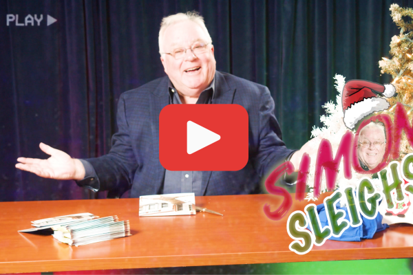 Simon Says YouTube Thumbnail. Simon at his desk with Christmas decorations and shrugging. The words "Simon Sleighs" in the corner.