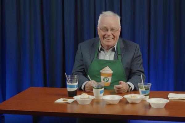 Dean Simon Sheather testing different fall foods in a green apron.