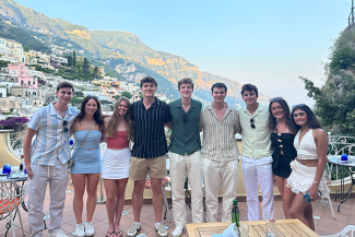 Students posing for a photo in front of a beautiful landscape