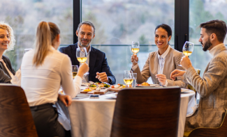 Smiling coworkers in restaurant talking during business lunch