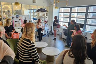 An instructor speaks to a room of art students