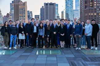 Wall Street Scholars standing on the roof of a New York City Building with the City Skyscrapers behind them.