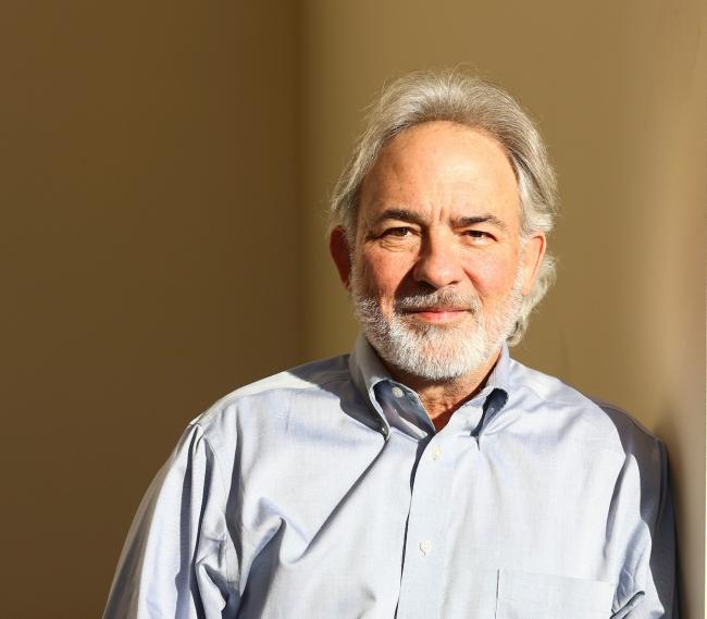 Steve Borgatti poses for a photo in a sun-drenched stairwell