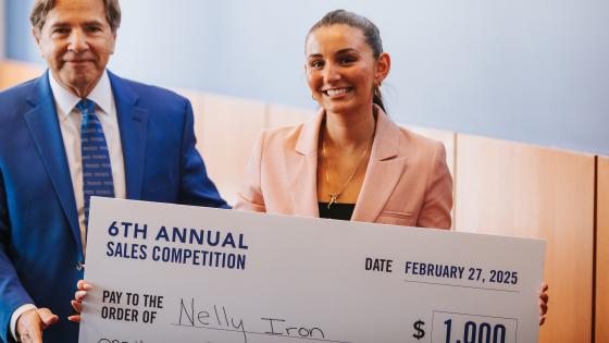 The winner of the 6th annual sales competition, Nelly Iron, poses with event coordinator, Michael Johnston, with her first prize check