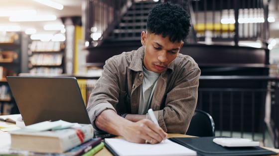 Man taking notes in library
