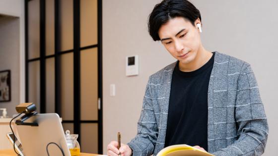 Man studying folder while taking notes