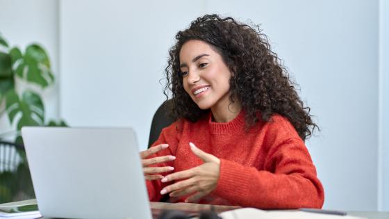 Happy latin business woman having video call hybrid meeting in office.
