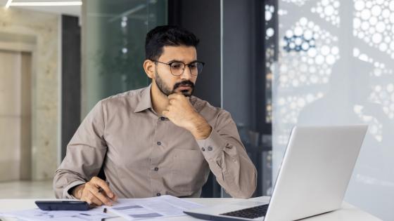 Man thinking while looking at laptop