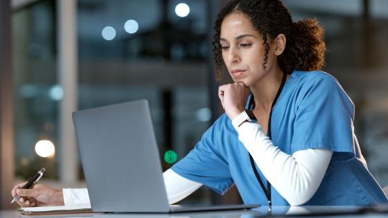 Healthcare Worker reading with a Laptop