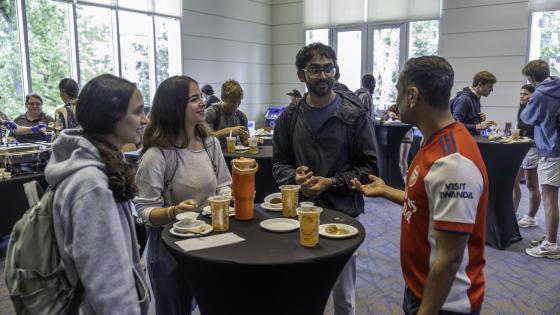 Multiple students discussing stories with faculty member Darshak Patel, PhD
