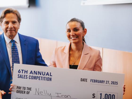 The winner of the 6th annual sales competition, Nelly Iron, poses with event coordinator, Michael Johnston, with her first prize check