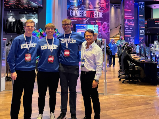 UK Excel Financial Modeling team poses for a picture. From left to right, Paul Kreinbrink, John Lubert, Colin Albrecht, John Saliling. All team members are wearing coordinating UK sweatshirts and Microsoft Excel Collegiate Challenge lanyards and name tags