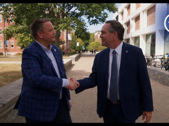 Interim Dean, Chris Clifford, shaking hands with Craig Carlson