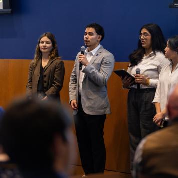 students in Gail Hoyt's Economics of Altruism course present their proposal in front of their class at the end of semester celebration
