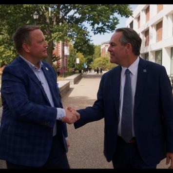 Interim Dean, Chris Clifford, shaking hands with Craig Carlson